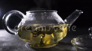 茶叶酿造。 绿茶叶在玻璃壶中旋转。